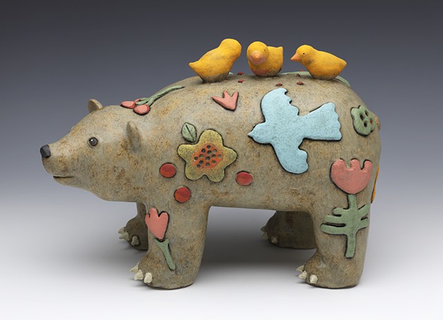 bear with colorful motifs and 3 birds gathered on top