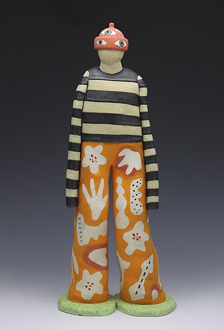 Figure in striped shirt, decorative pants and hat with eyes