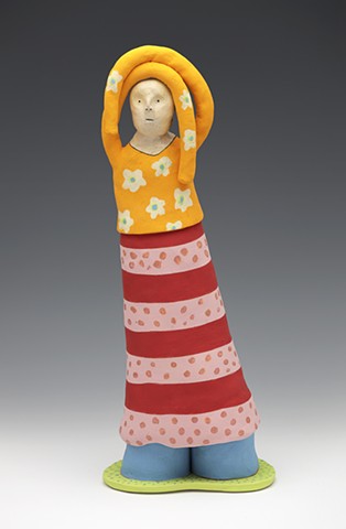 Colorful figure with arms draped over head