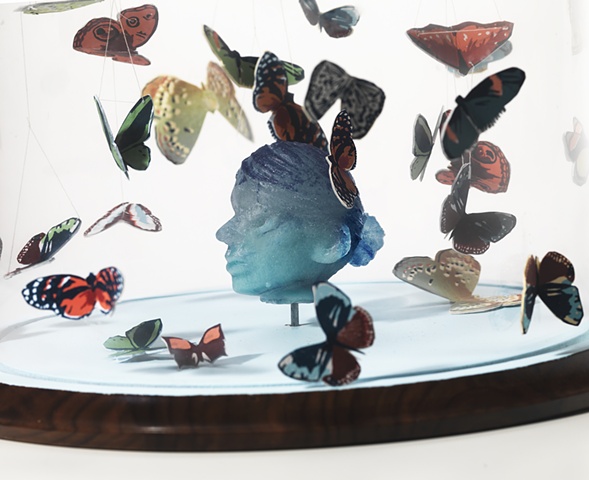 cast glass head with silkscreen butterflies in bell jar by leigh craven