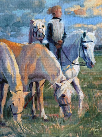 A girl on a horse holding 3 other horses.