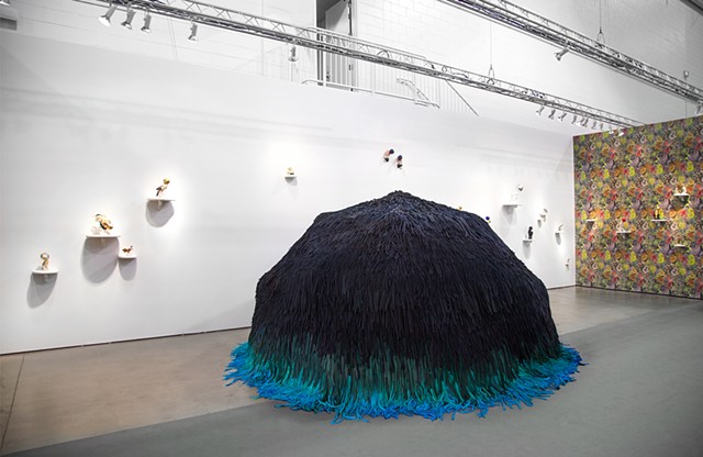 Installation view at EXPO Chicago showing the 10 ft wide enter-able 'Tell it to the Birds' dome, 'Natural Camouflage Lichen Wallpaper' and fungus-shaped shelves displaying bird sculptures from the 'Camouflage' series