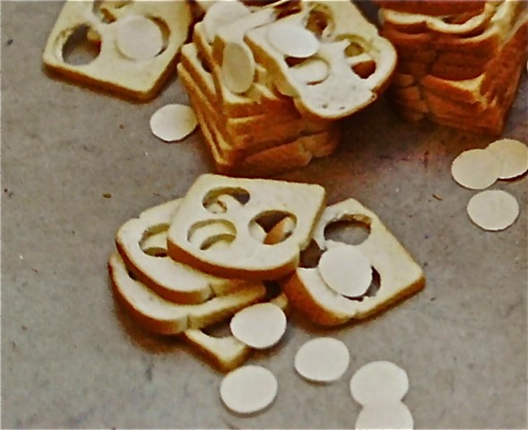 Stacks of white bread with 3 circles each removed and thrown around the stacks.