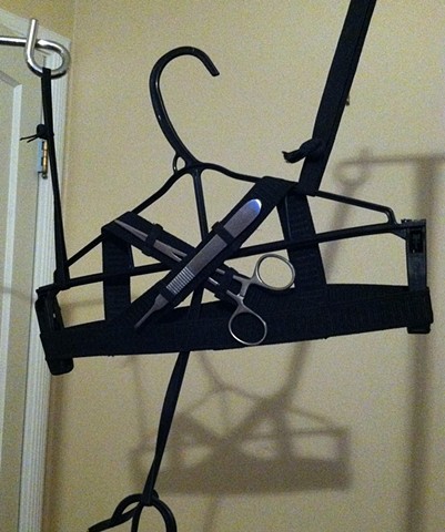 Black elastic bra and thong loaded up with tools for feminine survival.