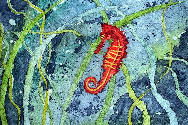 A bright red seahorse swims in the deep blue sea.