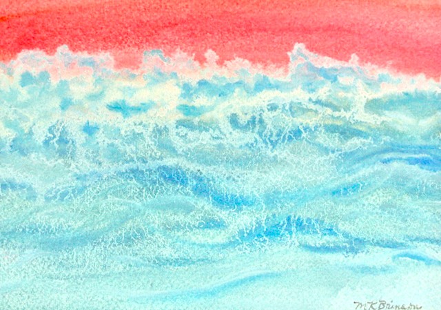 An aquamarine ocean whips its waves into a froth at sunrise.