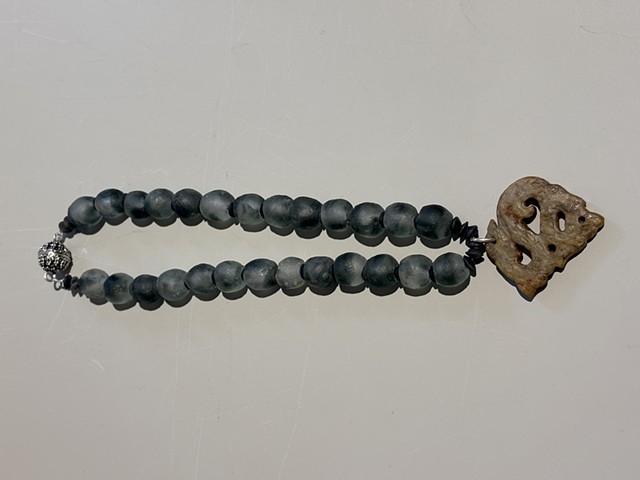 Smoky slate glass beads with serpentine spacers and an ancient Tibetan carved jade pendant (25009)