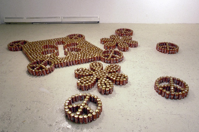 empty coke cans arranged on the floor in a "peace and love" pattern