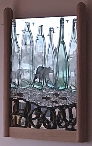 Mirror with fish, geese, and a bear abraded in the silvering.  Slumped and fused bottles, tempered glass crumbs, red frit.