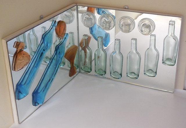 Mirrors at a right angle.   Slumped bottle parts and glasses.   For a corner or pedestal.