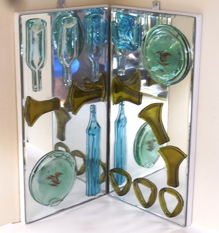 Slumped and fused bottle glass on mirrors that are on hinged plywood.   Hangs in a corner. 