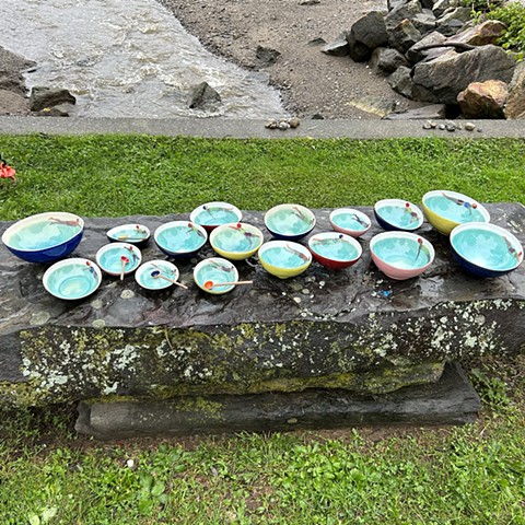 Bowls with paintings of swimmers in them and turquoise water.