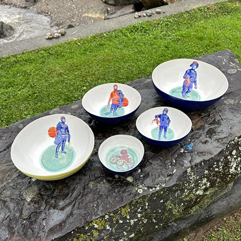 Haenyeo women and octopuses painted in bowls with turquoise glaze.