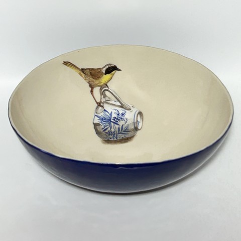 Painted yellowthroat bird with pottery shard on porcelain bowl.
