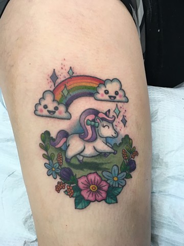 fun unicorn and rainbow tattoo with flowers and clouds by the artist Kristin of Strange World Tattoo in Calgary, Canada