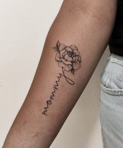 flower tattoo with script in the stem Strange World Tattoo Calgary Alberta Canada