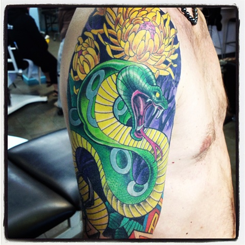 Cobra snake and chrysanthemum flower tattoo half sleeve by artist Brett Schwindt at Strange World Tattoo in Calgary, Alberta