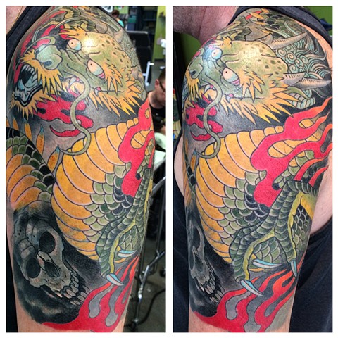 Dragon and skull half sleeve tattoo by the artist Brett Schwindt of Strange World Tattoo in Calgary, Alberta