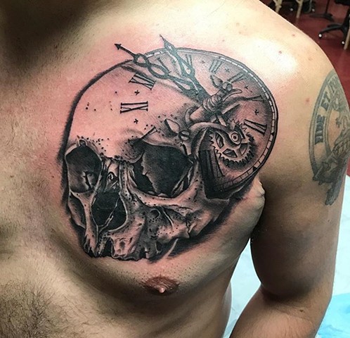 skull tattoo with clock in black and grey Strange World Tattoo Calgary Alberta Canada