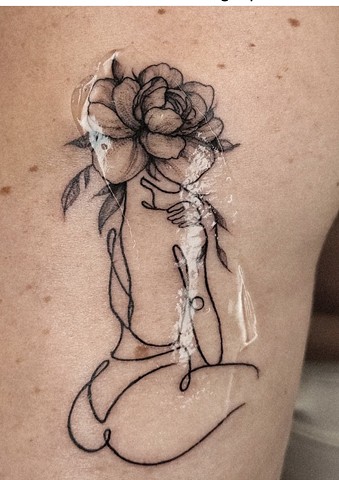 woman with flower head tattoo Calgary tattoos Strange World Tattoo