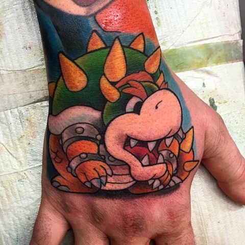 Super Mario Bowser colour hand tattoo by tattoo artist Brett Schwindt at Strange World Tattoo in Calgary, Canada