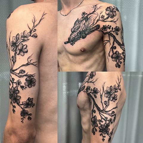 Strange world tattoo Calgary alberta Canada Valeriia Ukrainian artist soft black and grey aggressive looking Kitsune holding a kitana in its mouth coming off arm and onto chest peck area upper arm from shoulder to elbow filled with branches of cherry blos