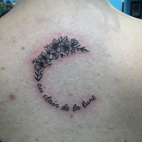 moon with flower and script tattoo