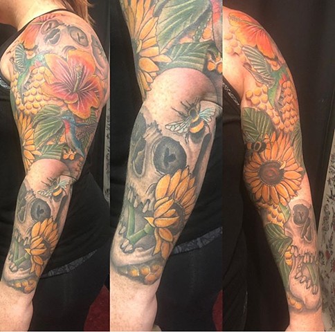 Skull, hummingbirds, bees and flowers full sleeve colour tattoo Strange World Tattoo Calgary 