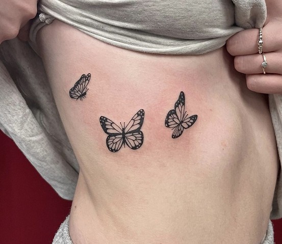 Dainty butterflies on ribs strange world tattoo Calgary tattoo artists alberta Canada fineline trendy feminine