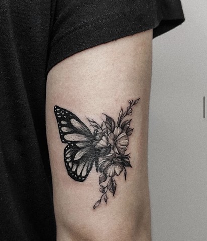 half butterfly, half flowers tattoo in black and grey Strange World tattoo Calgary Canada 
