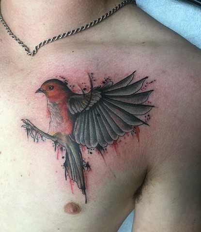 Watercolour bird tattoo on chest Strange World Tattoo Calgary 