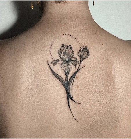 flower tattoo on upper back in black and grey Strange World Tattoo Calgary Alberta Canada