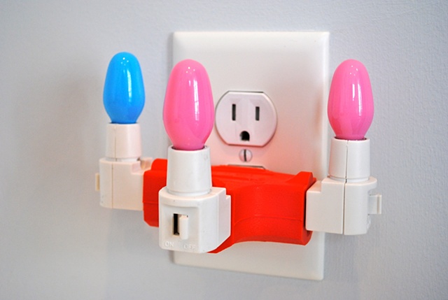 Three-way Adapter is made of electric adapter and light bulbs. Sculpture at Art of the Auction at North Carolina Museum of Art in Raleigh, NC. New York NY. School of Visual Arts. Skowhegan School of Painting and Sculpture. Mary Carter Taub is an installat