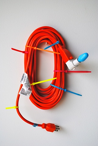 Orange Lasso sculpture is made of power cord, electric ties, electric adapter and light bulb. Sculpture at Art of the Auction at North Carolina Museum of Art in Raleigh, NC. New York NY. School of Visual Arts. Skowhegan School of Painting and Sculpture. M