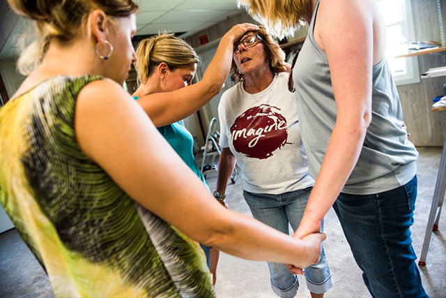 Cindy Carbaugh, middle background, is prayed for by Kelley Latta, background left, Juliet Sharrow, and Kirsten Schaub, right, Saturday June 25, 2016 while the group prepared a warehouse in Hanover for the Love LIVES headquaters. 