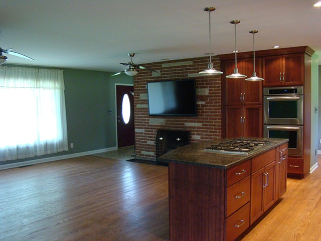 Looking into the kitchen and living room area, showing the new media on the fireplace wall.