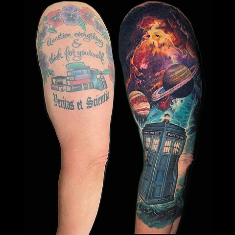 This custom Doctor Who TARDIS tattoo transforms an older upper arm piece into a fully realized space-themed cover-up sleeve. The original tattoo—featuring script, books, and floral elements—has been reworked into a vibrant galaxy scene with planets, nebulae, and the TARDIS emerging through space. The design blends sci-fi realism with painterly color work, using high-contrast lighting, deep blacks, and saturated reds, purples, and teals to fully obscure the previous tattoo while creating depth and movement across the arm. The TARDIS acts as the focal point, grounded against a dynamic cosmic background that wraps naturally with the body’s shape. This piece is a strong example of how a tattoo cover-up can go beyond concealment and become a completely new, cohesive work of art. Ideal for clien
