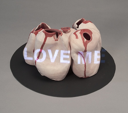 Wheel thrown and altered ceramic vessels with projected text "Love Me" by Linda S Fitz Gibbon