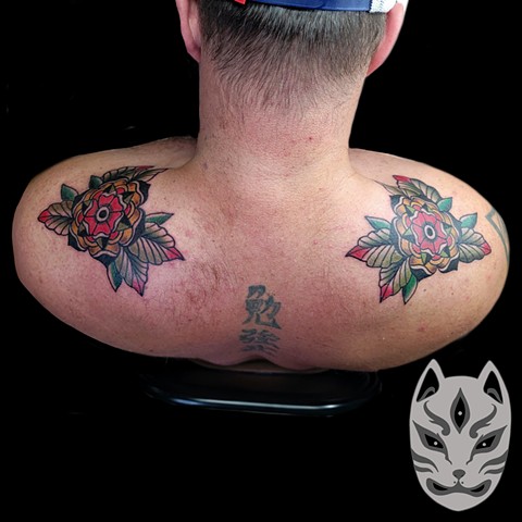 Traditional style flowers on shoulders by traditional tattoo artist Gina Matuo at copper fox tattoo in Kissimmee Florida. Best tattoo shop near me