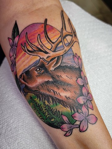 Traditional Style tattoo of elk with Flowers on a forearm in full color by Gina Matsuo of Copper Fox Tattoo in Kissimmee Florida best tattoo shop near me