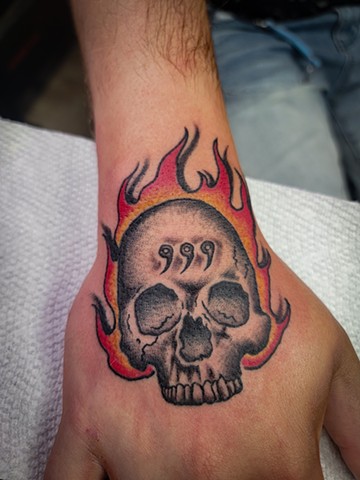 Juicewrld inspired Flaming Skull on Hand by Gina Matuo of Copper Fox Tattoo in Kissimmee Florida best tattoo shop in orlando