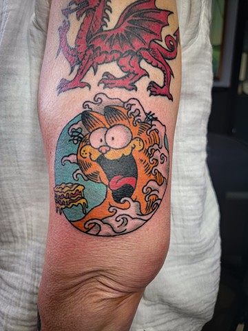 Garfield with Hokusai inspired waves tattoo on upper arm by Gina Matuo of Copper Fox Tattoo in Kissimmee Florida Friendliest tattoo shop 