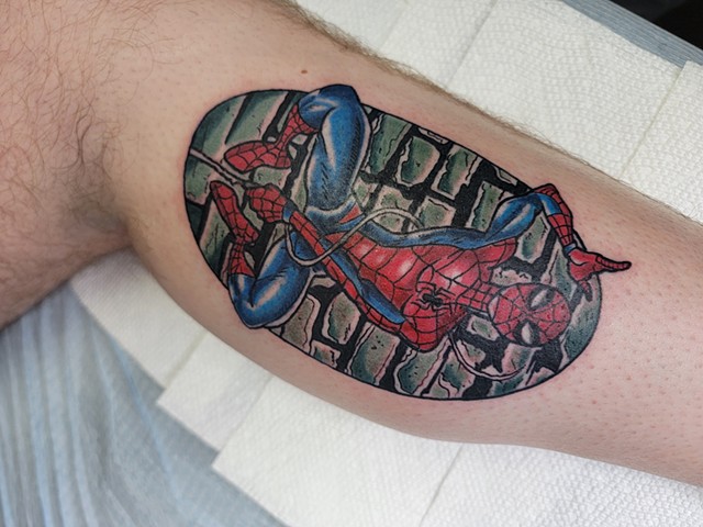 Spider-Man comic style trafitional tattoo in full color on lower leg by Gina Matsuo of Copper Fox in Kissimmee Florida best tattoo shop near me