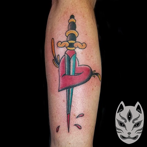 Heart with dagger on forearm in traditional style 