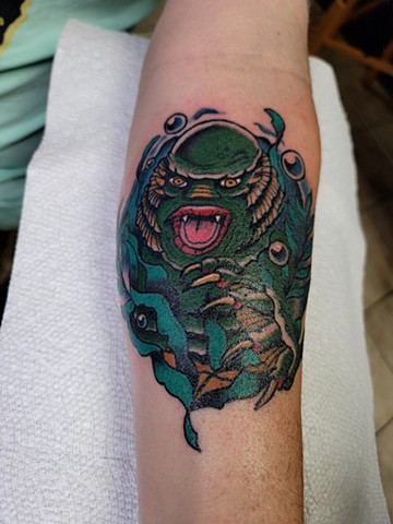 creature from the black lagoon tattoo in traditional style on forearm by Gina Matsuo at Copper Fox Tattoo in Kissimmee Florida best tattoo shop near me