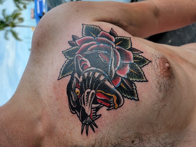 Traditional Black Panther with rose cover up tattoo on chest by Gina Matuo of Copper Fox Tattoo in Kissimmee Florida walk ins welcome best tattoo shop in Kissimmee 