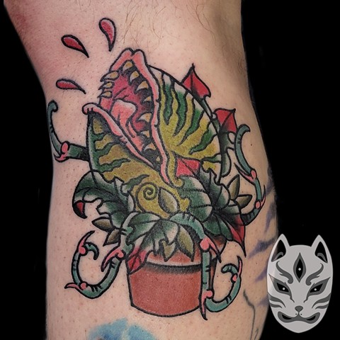 Audrey II from the film little shop of horrors in traditonal tattoo style in color on the calf by Gina Matuo of Copper Fox tattoo in Kissimmee Florida Best tattoo shop near me traditional tattoo artist