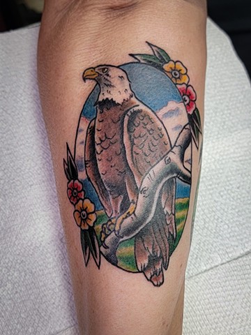 Traditional style tattoo of an eagle on a branch by with flowers on forearm by Gina Matsuo of Copper Fox Tattoo in Kissimmee Florida  best tattoo shop near me 