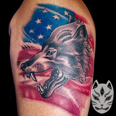 Wolf with American Flag tattooon upper arm 