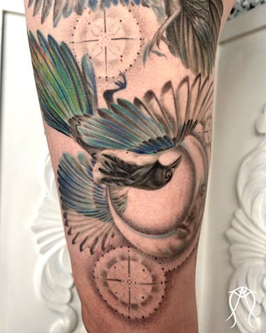 This is a color tattoo done by female tattoo artist Amanda Marie in central New York it features a crow and magpie with two moons and stars done in a fine line style of tattooing Amanda is a multidisciplinary artist and witch as well as herbalist and tarot reader and  loves creating nature based and spiritual tattoos